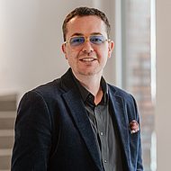 Business-Porträt eines Mannes mit Brille im modernen Büroambiente, leger-eleganter Business-Look