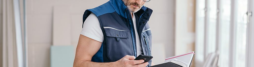 Zdjęcie rzemieślnika z telefonem komórkowym i notatnikiem
