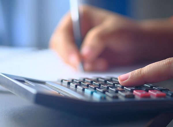 Zbliżenie ręki piszącej na kalkulatorze